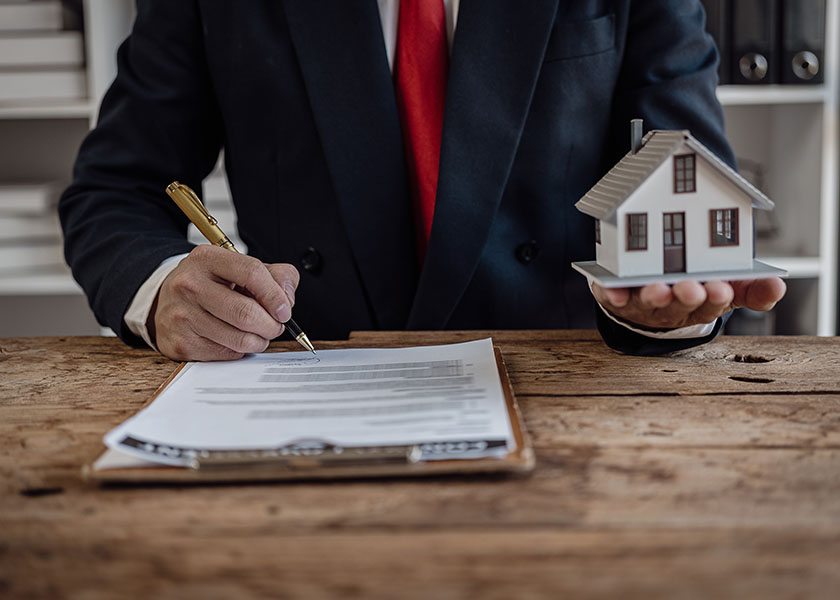 Businessman analyzing financial investments in an office, symbolizing protection, real estate sales, and insurance care.